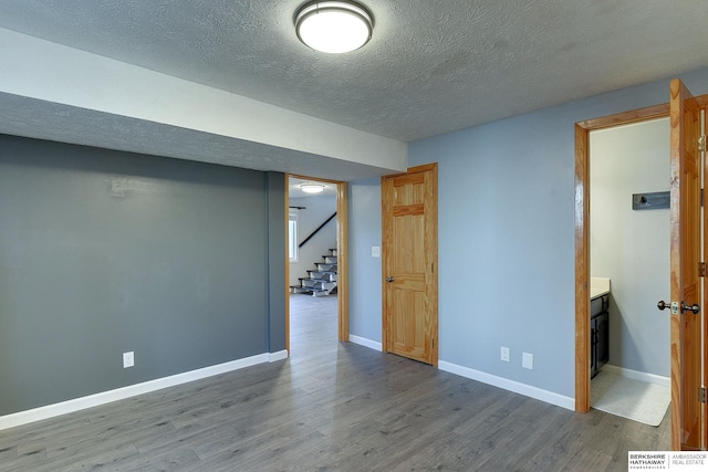 spare room with a textured ceiling and wood-type flooring