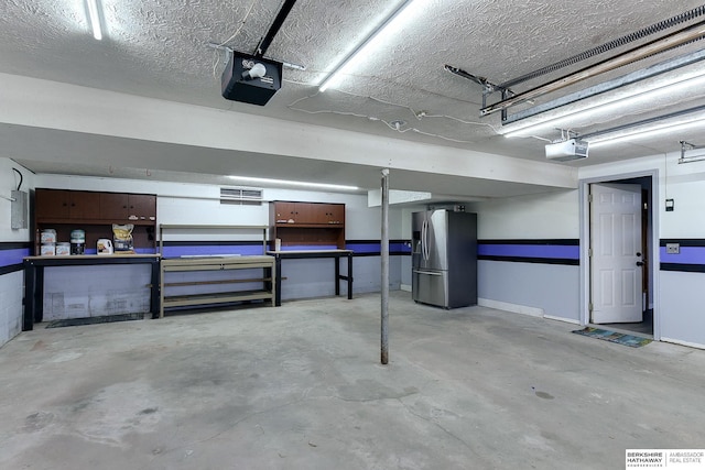 garage featuring stainless steel fridge and a garage door opener