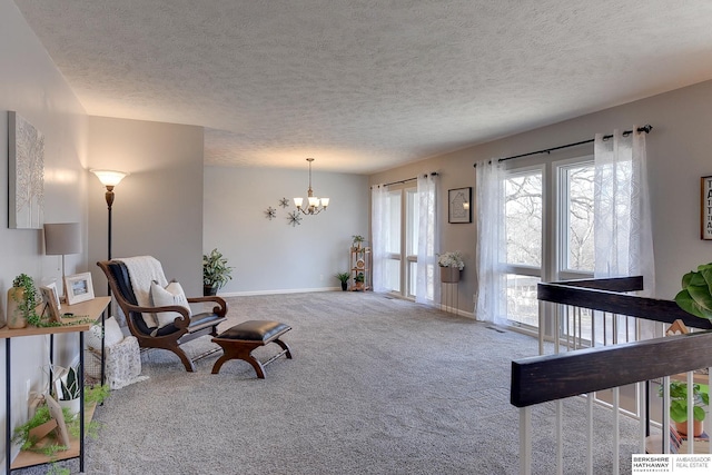 sitting room featuring carpet floors, a textured ceiling, and a chandelier