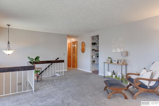 unfurnished room featuring a textured ceiling, carpet, and built in shelves