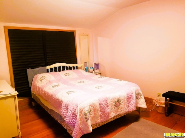 bedroom featuring wood-type flooring and vaulted ceiling