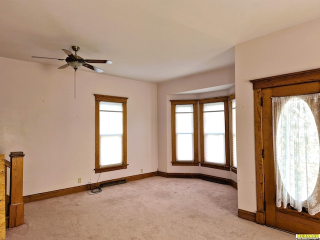 foyer featuring light carpet and ceiling fan