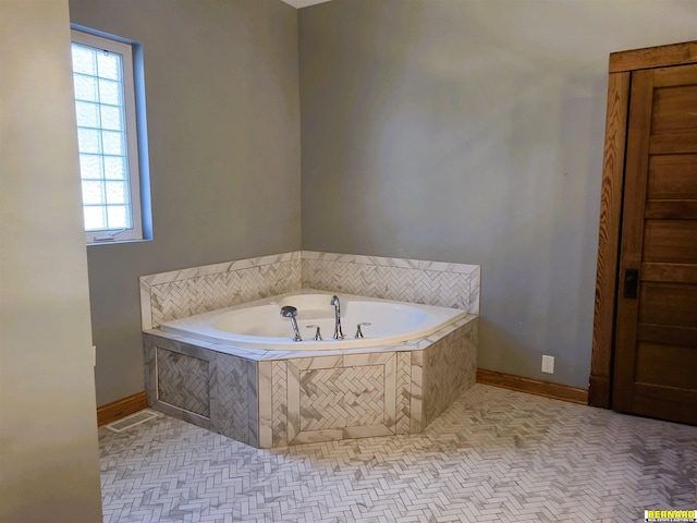 bathroom featuring a relaxing tiled tub and tile patterned floors