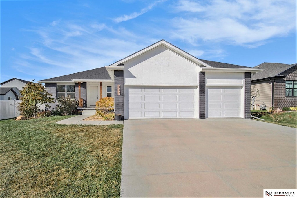 ranch-style home with brick siding, stucco siding, concrete driveway, an attached garage, and a front yard