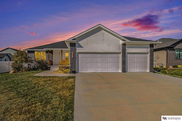 ranch-style home featuring a garage and a yard