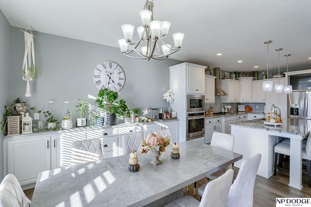 dining area featuring dark wood-type flooring, sink, and a notable chandelier