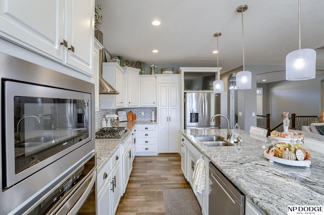 kitchen featuring decorative light fixtures, decorative backsplash, sink, white cabinetry, and appliances with stainless steel finishes