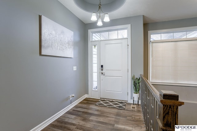 entryway featuring dark wood-type flooring and a notable chandelier