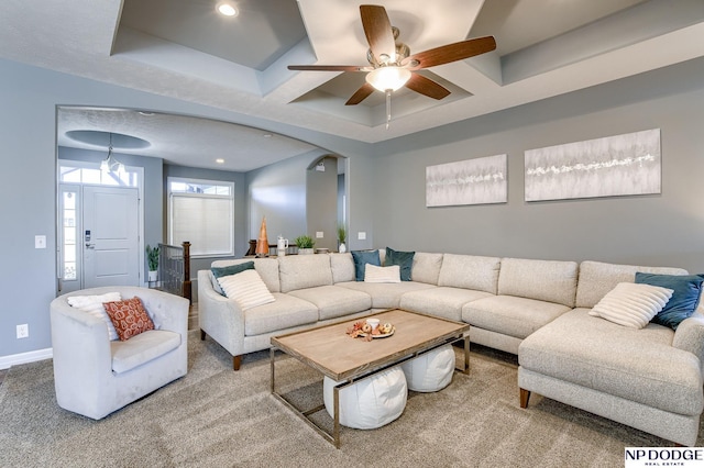 carpeted living room featuring ceiling fan, beamed ceiling, a tray ceiling, and coffered ceiling