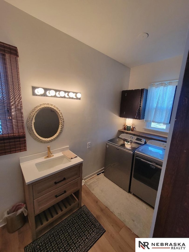 kitchen featuring light hardwood / wood-style floors, sink, and independent washer and dryer