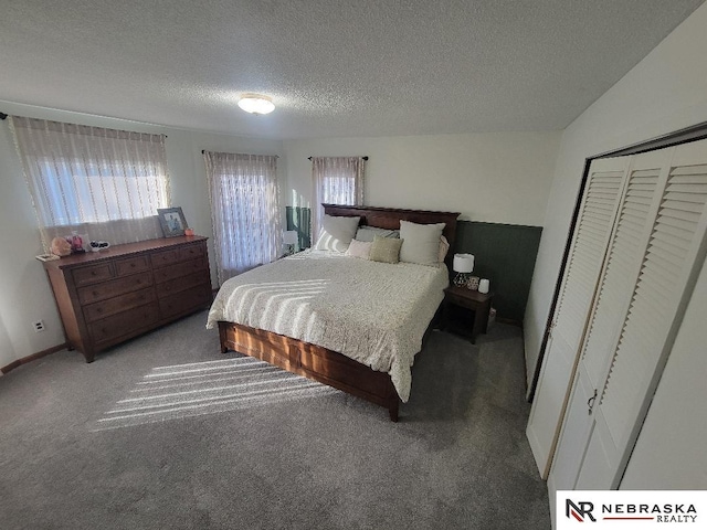 carpeted bedroom with a closet and a textured ceiling