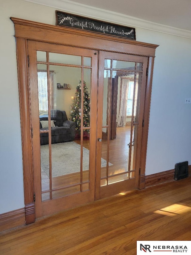 doorway featuring wood-type flooring and ornamental molding