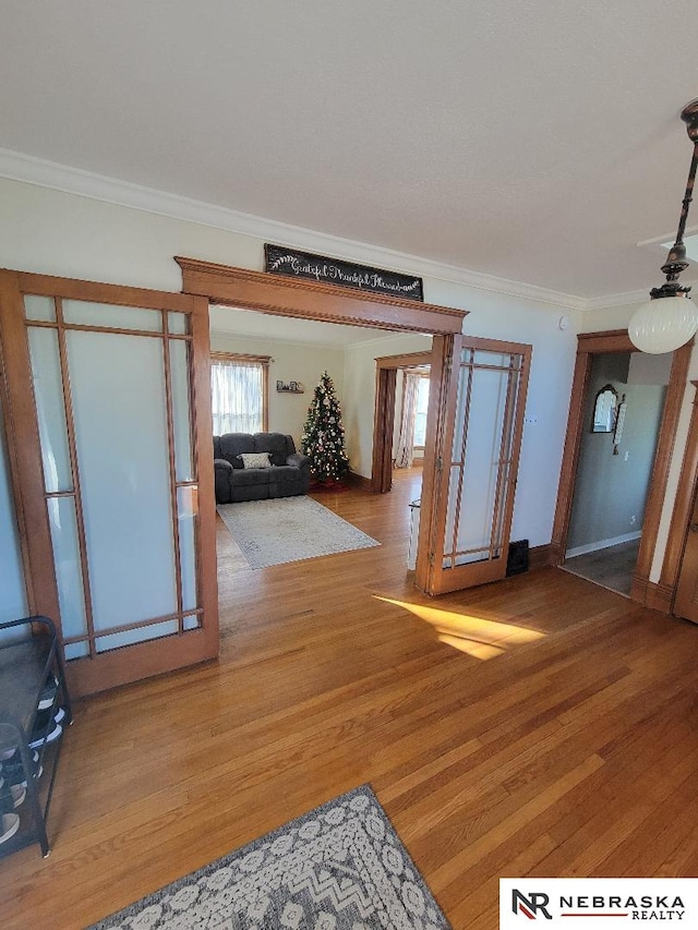 entrance foyer with hardwood / wood-style floors and ornamental molding