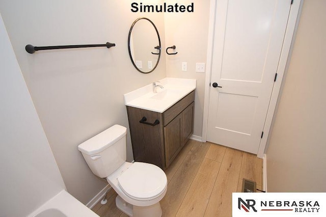 bathroom featuring toilet, wood-type flooring, and vanity