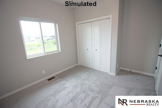 unfurnished bedroom featuring light colored carpet and a closet