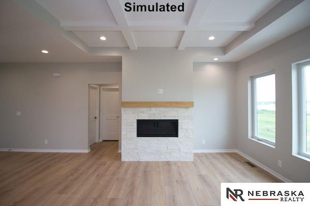 unfurnished living room with light hardwood / wood-style floors, beam ceiling, a stone fireplace, and coffered ceiling