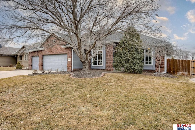 view of front facade with fence, a front lawn, concrete driveway, and brick siding