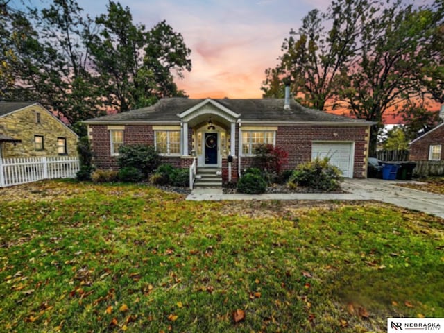 ranch-style home featuring a garage and a yard