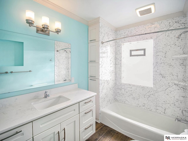 bathroom featuring hardwood / wood-style flooring, tiled shower / bath combo, vanity, and crown molding