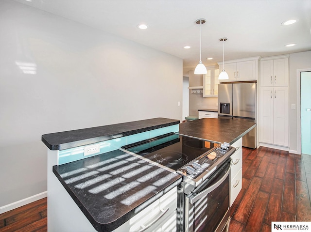 kitchen with dark wood-type flooring, white cabinets, appliances with stainless steel finishes, and a kitchen island