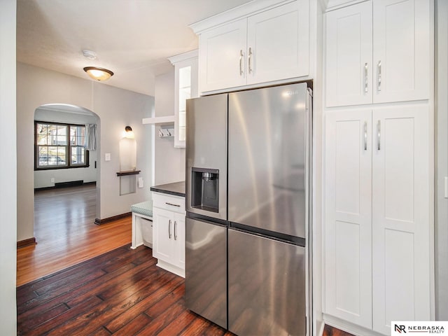 kitchen with stainless steel refrigerator with ice dispenser, dark hardwood / wood-style floors, and white cabinetry