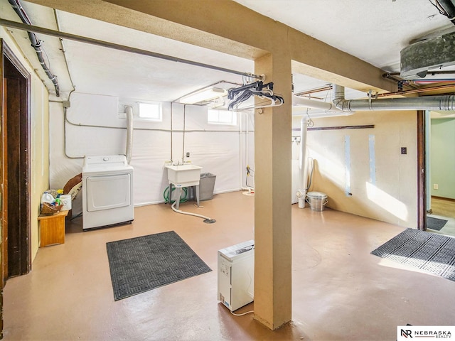 basement featuring washer and clothes dryer and sink