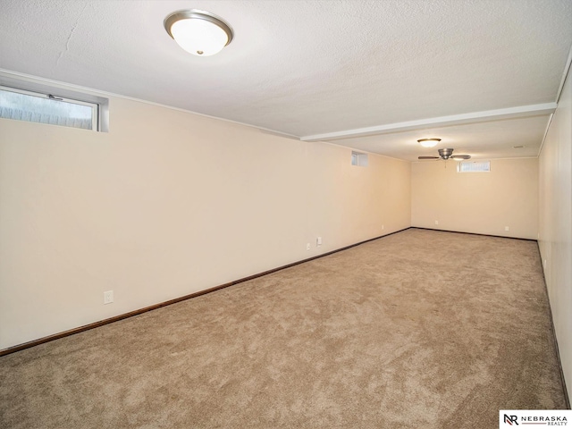 basement with a textured ceiling and light carpet