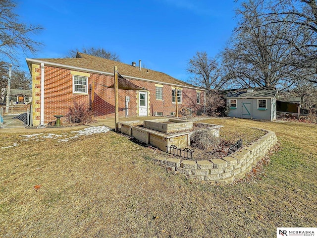 rear view of property featuring a yard and a storage unit