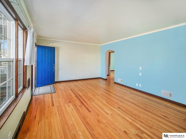 spare room featuring ornamental molding and light wood-type flooring