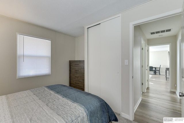 bedroom featuring light wood-type flooring and a closet