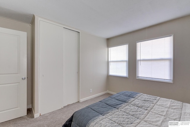 bedroom featuring light carpet and a closet