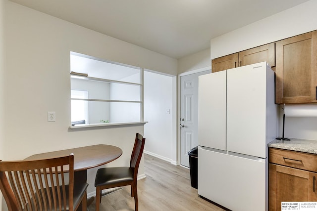 kitchen with white fridge and light wood-type flooring