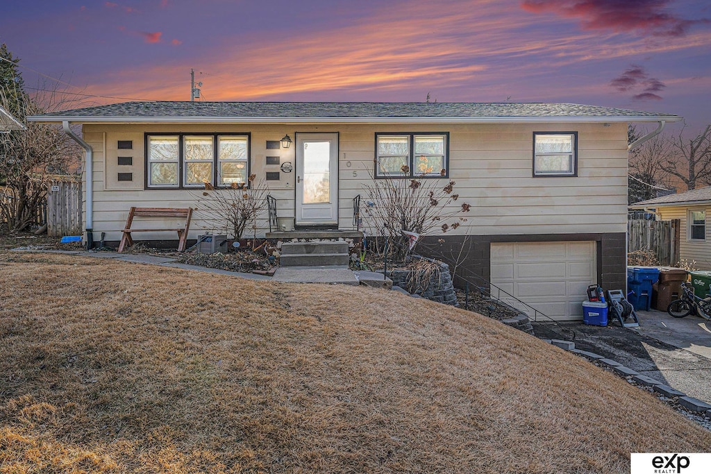 view of front of home featuring a garage and a yard