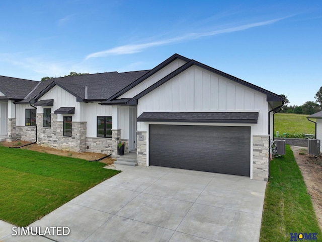 view of front of property with a front lawn, central AC unit, and a garage