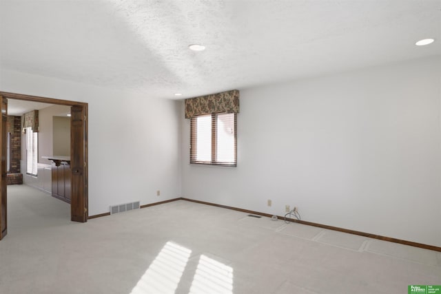 carpeted spare room with a textured ceiling