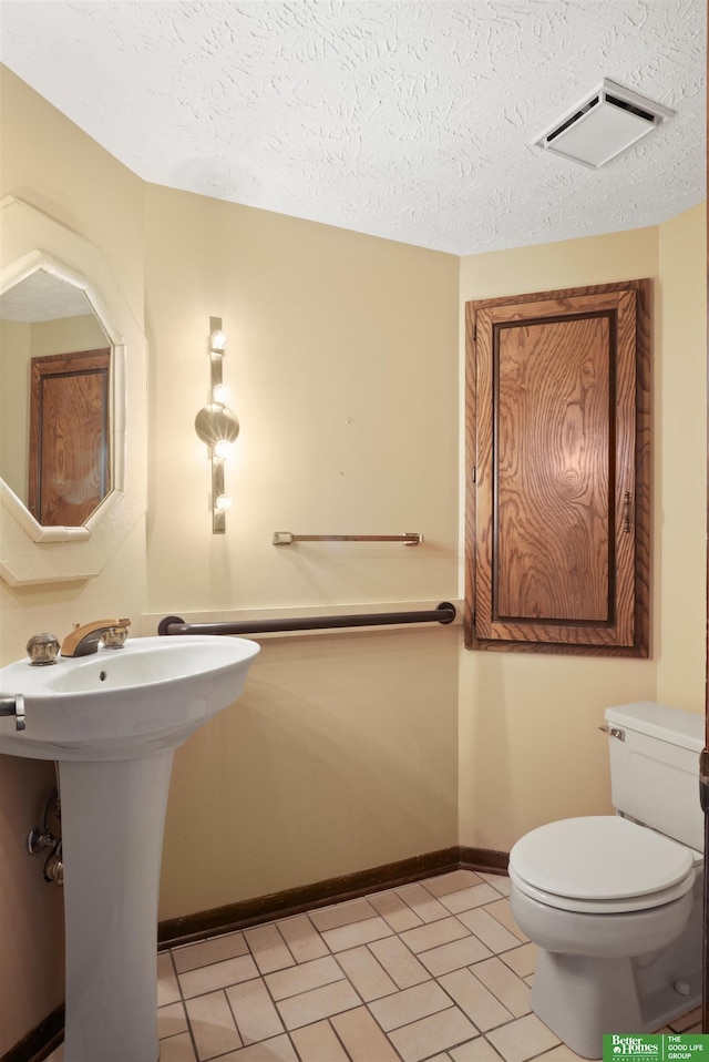 bathroom with a textured ceiling and toilet