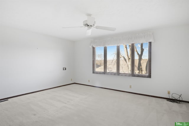 carpeted spare room featuring ceiling fan