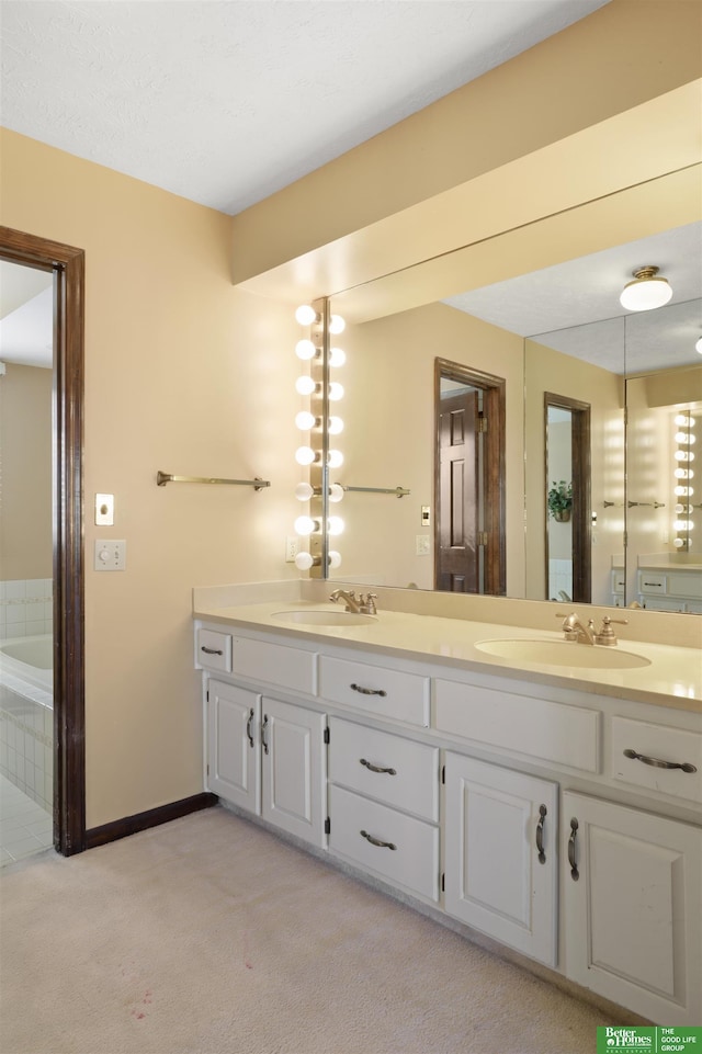 bathroom featuring tiled tub and vanity