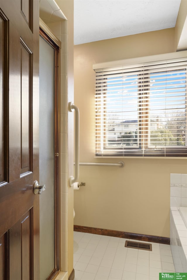 bathroom featuring tile patterned floors and independent shower and bath