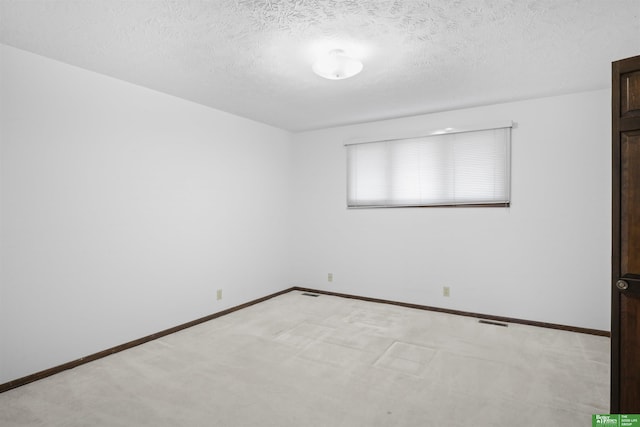 carpeted empty room with a textured ceiling