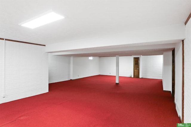 basement with brick wall and dark carpet