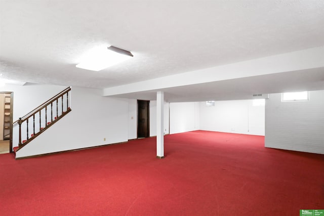 basement featuring carpet and a textured ceiling