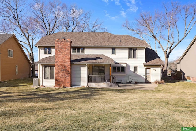 back of property with a yard and a patio