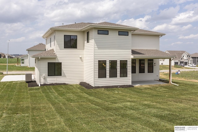 back of property with a lawn, central air condition unit, and a patio