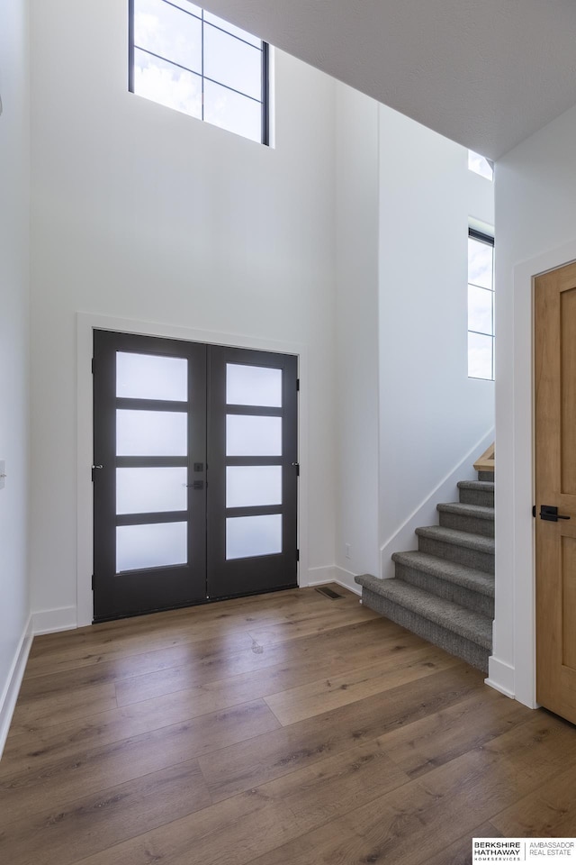 entrance foyer with hardwood / wood-style flooring, a wealth of natural light, and french doors