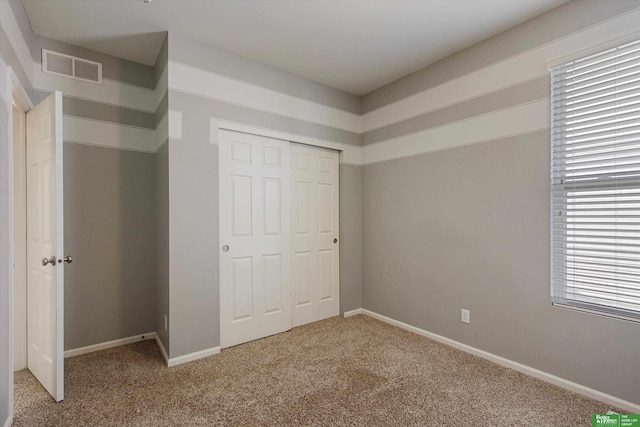 unfurnished bedroom with a closet and carpet flooring