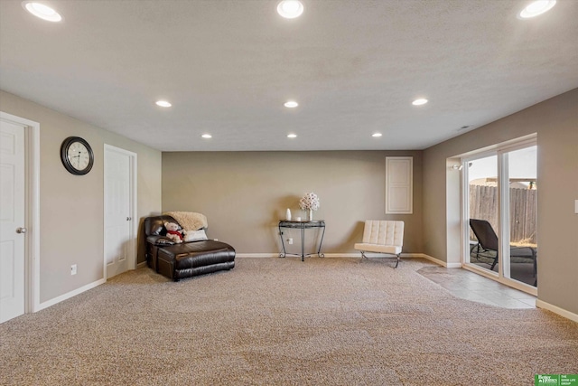 living area with a textured ceiling and light carpet