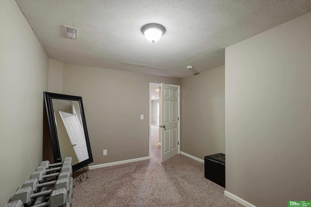 spare room featuring a textured ceiling and carpet