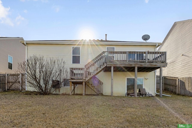 back of house featuring a deck and a lawn