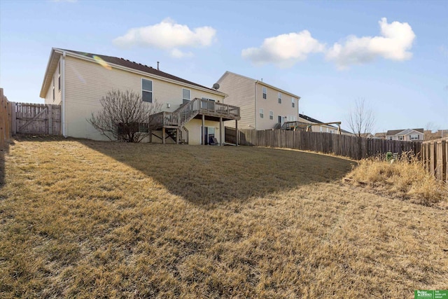 back of property with a wooden deck and a yard